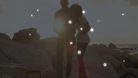 Animation-of-stars-over-african-american-couple-at-beach