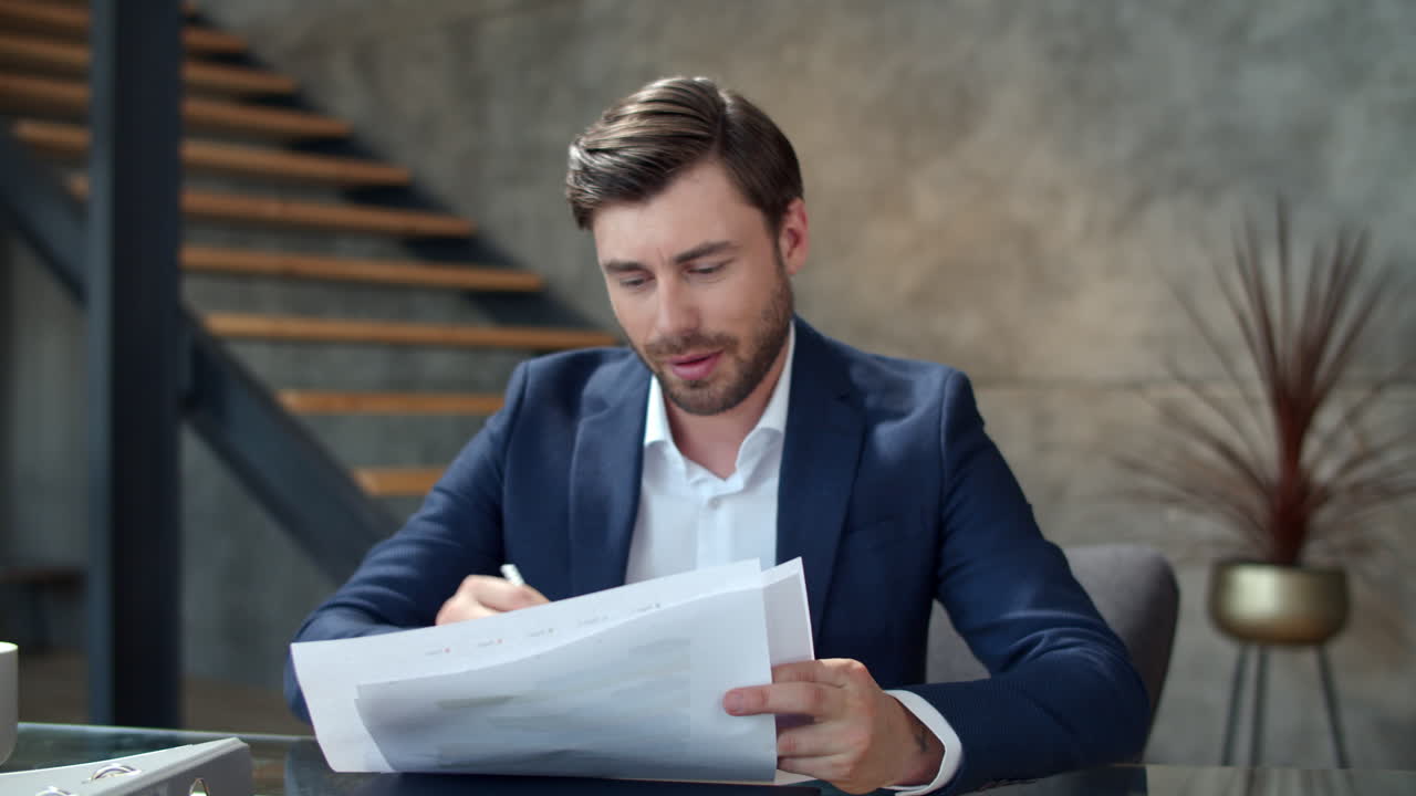 Happy businessman working with documents in modern office. Manager making notes.