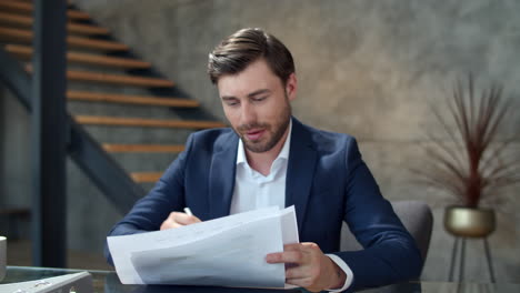 un hombre de negocios feliz trabajando con documentos en una oficina moderna. un gerente tomando notas.
