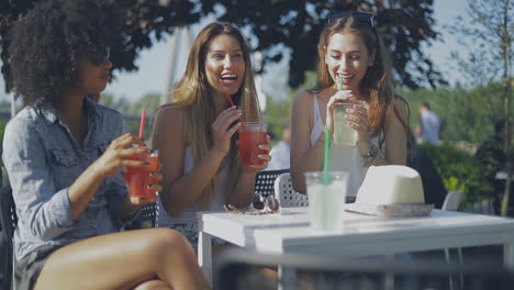 stylish young girls having drinks outside