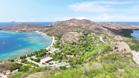 sunny coastal of flores, indonesia. sandy beach, hotel and crystal clear waters. drone