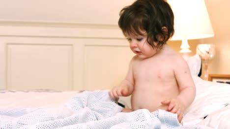 una niña linda sentada en la cama