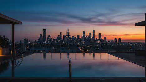 stunning sunset skyline view over tranquil pool reflecting the city lights at dusk, showcasing urban beauty and serenity in the evening sky