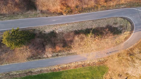 Motorcycle-rider-driving-up-a-switchback-road-at-sunset