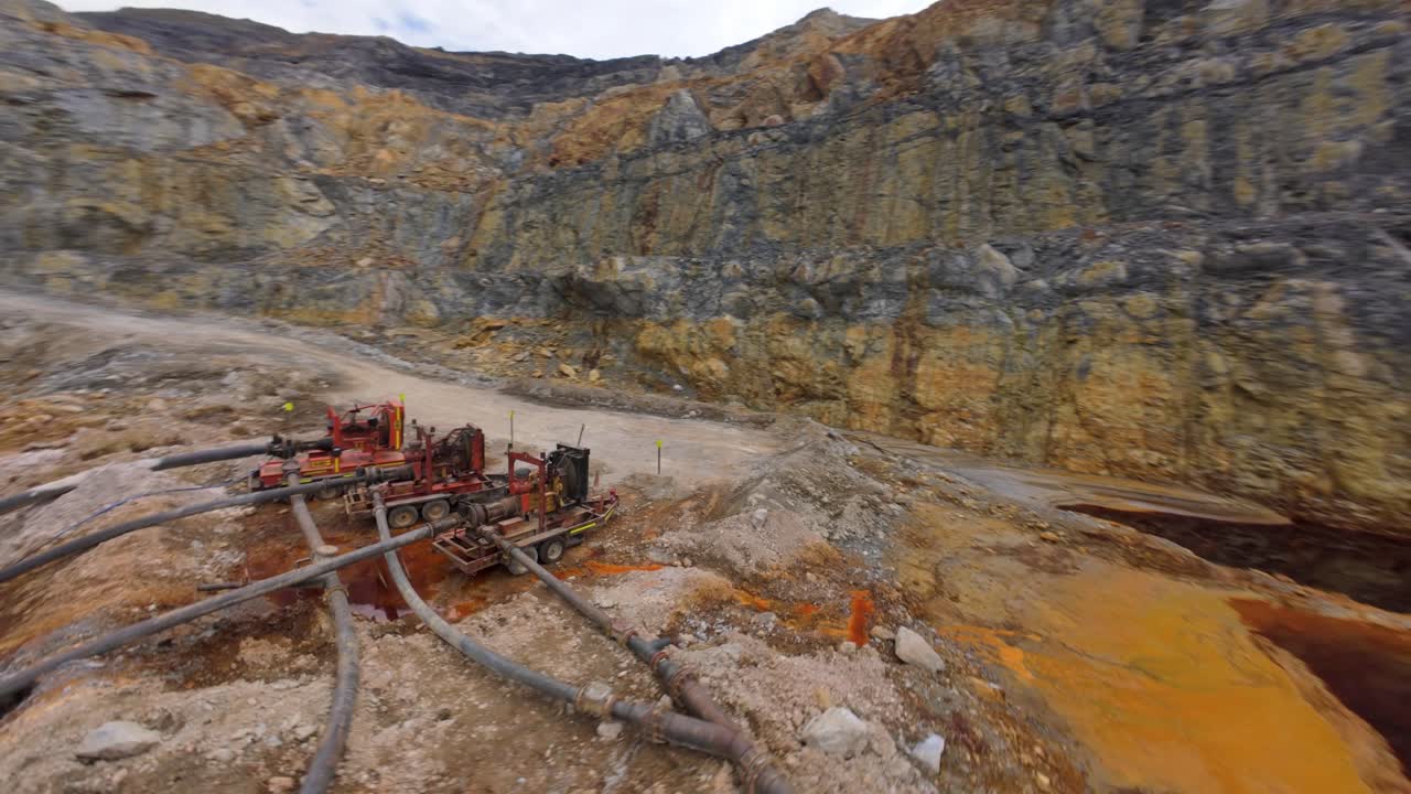 Water pumps emptying open pit mine for gold and silver extraction, fpv drone