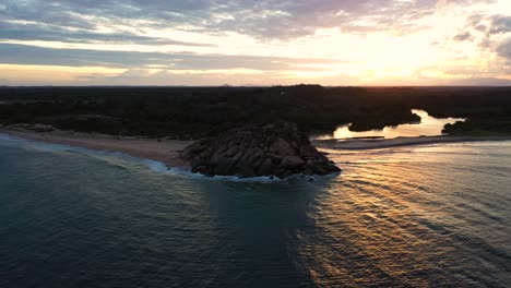 aerial of elephant rock during colorful sunset in popular surfing destination of arugam bay, sri lanka.