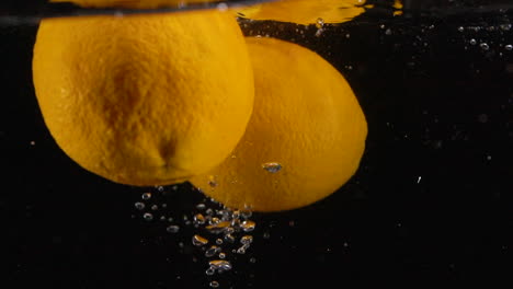 many slow motion fresh orange oranges splash in water with bubbles