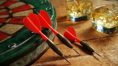 Dart-and-whisky-on-wooden-table-4k