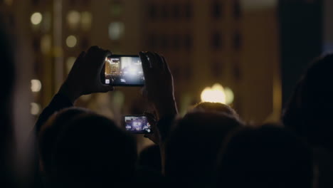 Vista-Desde-Detrás-De-Las-Manos-Sostenga-El-Teléfono-Inteligente-Entre-La-Gente-En-Una-Fiesta-Rave-Con-Luz