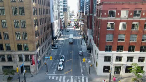 Drone-flying-between-sky-scrapers-looking-down-at-traffic-in-downtown-Toronto