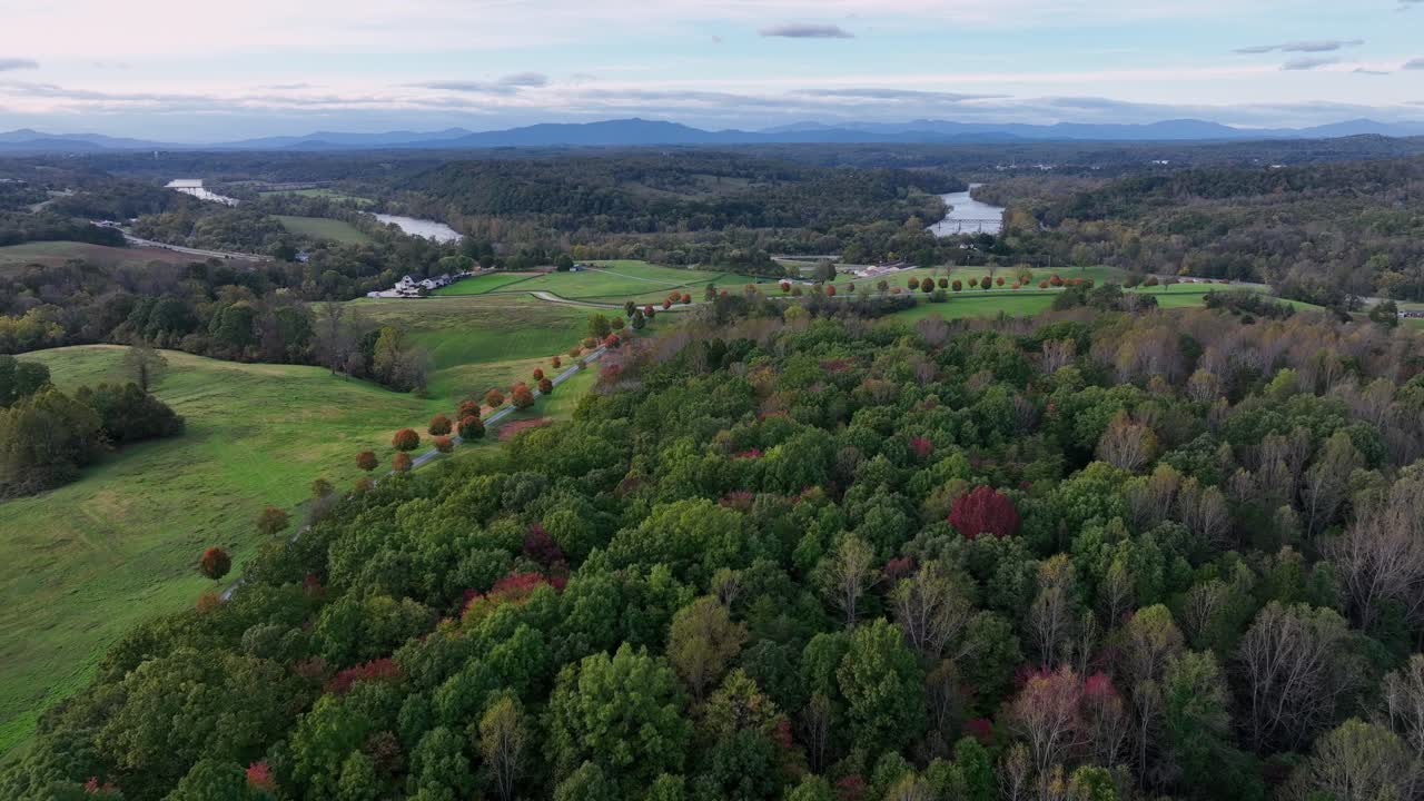 Aerial flyover american scenic landscape of american with colorful trees along street. Autumn day in american suburb. Aerial birds eye wide shot.