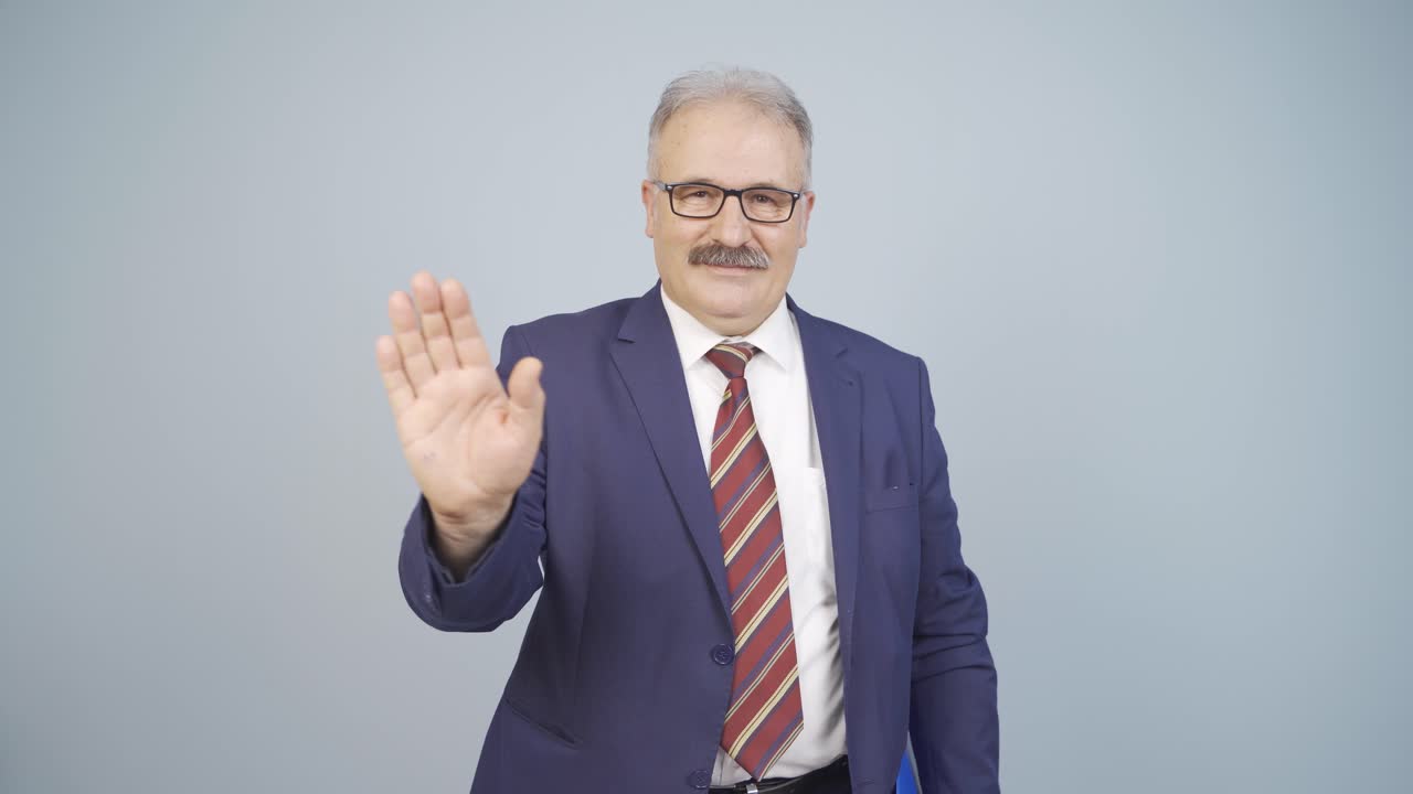 Uomo d'affari che saluta la telecamera.