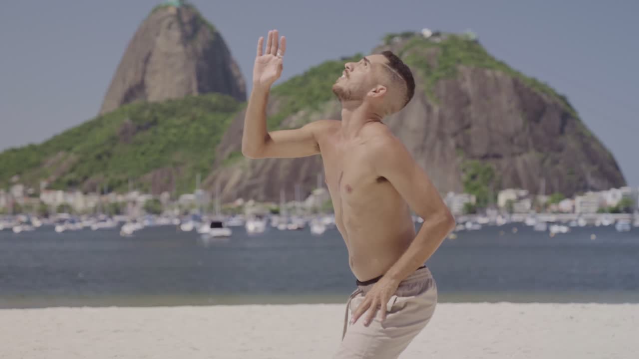People playing footvolley on a beach in Rio de Janeiro with Sugarloaf Mountain in the background