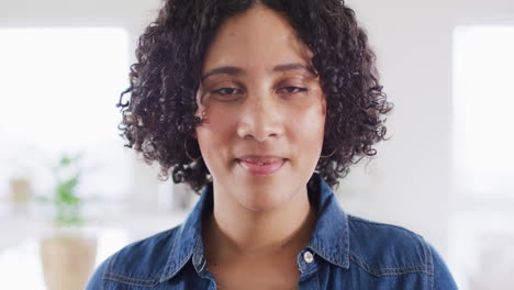 portrait of biracial woman looking to camera and smiling, in slow motion