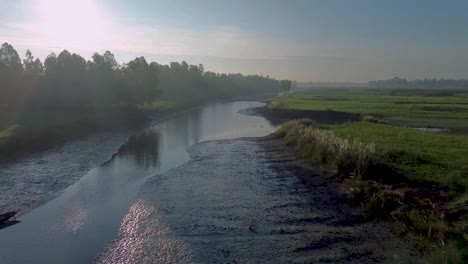 Clip-De-Drones-Del-Canal-De-Agua-Fangosa-En-Las-Fértiles-Llanuras-Aluviales-De-Las-Tierras-Agrícolas-De-La-India