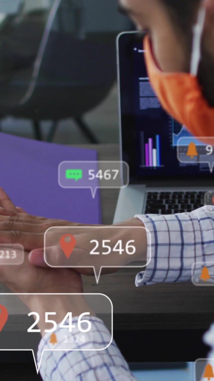 Animation of social media icons over man wearing face mask using hand sanitizer at office