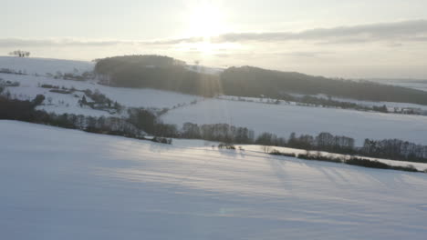 aerial shot of snow covered farm land at sunrise, winter in rural czech republic