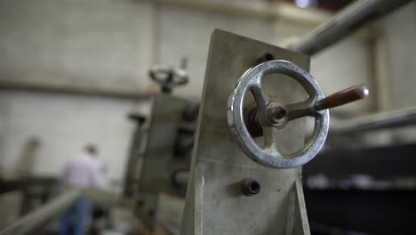 a slow dolly in of a forged steel valve wheel with a silhouette of a working man