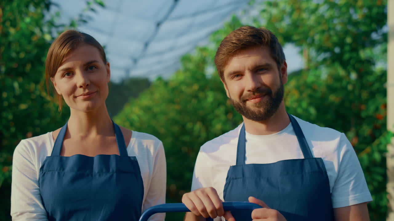 agrónomos sonriendo en una casa de plantación moderna.