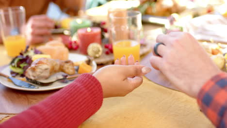 happy diverse male and female friends eating thanksgiving celebration meal in sunny garden