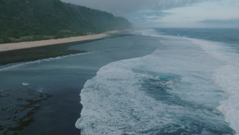 Zeitlupen-Drohne-Mit-Wellengang-Bei-Sonnenuntergang-Bei-Ebbe-über-Korallen--Und-Felsenriffen,-Nyang-Nyang-Beach,-Bali,-Uluwatu,-Indonesien