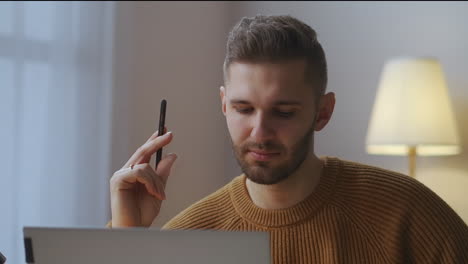 hombre se está comunicando por llamada de video en la computadora portátil escuchando y respondiendo retrato en la habitación trabajando desde casa comunicación remota de colegas