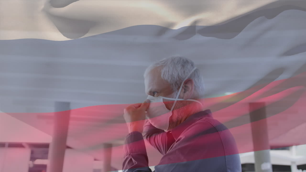 러시아 국기가 흔들리는 카우카시안 시니어 남자가 거리에서 얼굴 마스크를 쓰고 있습니다.