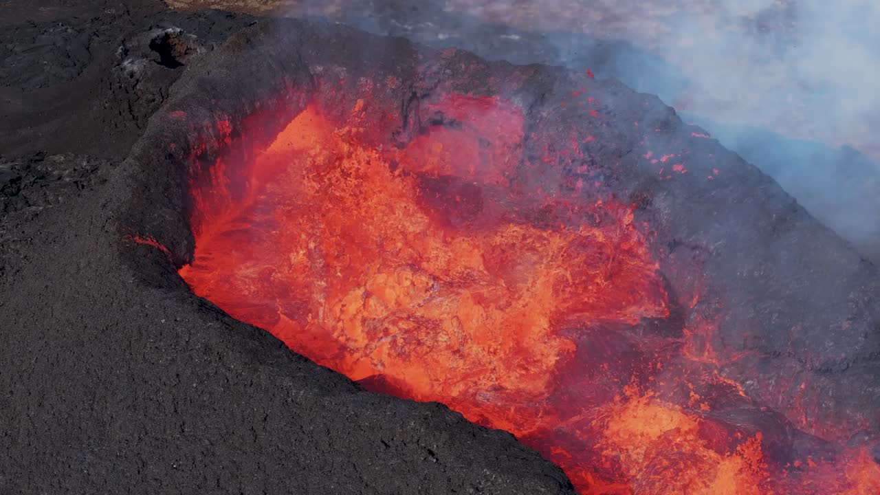 Fiery magma bubbling in volcano crater hole of Litli-Hr&uacute;tur, aerial