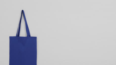 primer plano de la bolsa azul sobre fondo blanco, espacio de copia, cámara lenta