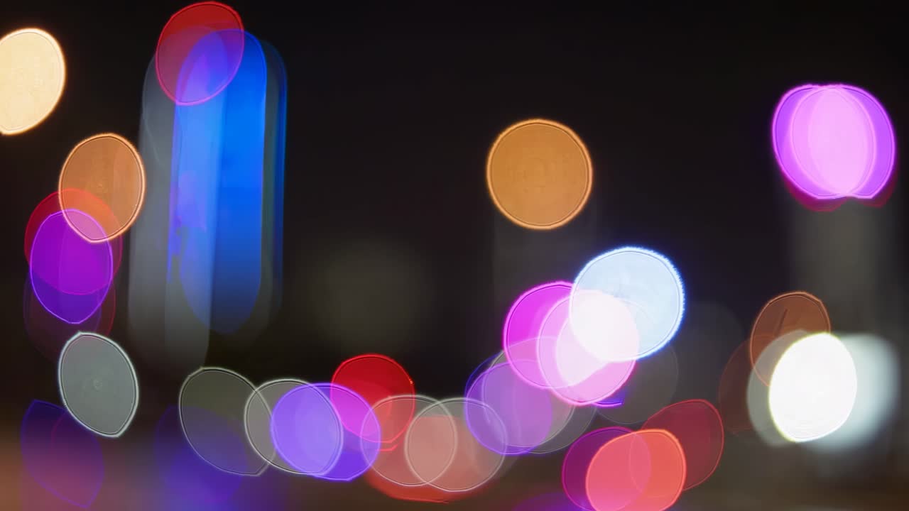 Abstraktes Videokonzept mit bunten Bokeh-Lichtern bei Nacht.