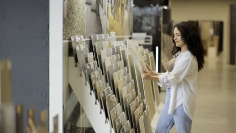 woman choosing tiles in a showroom