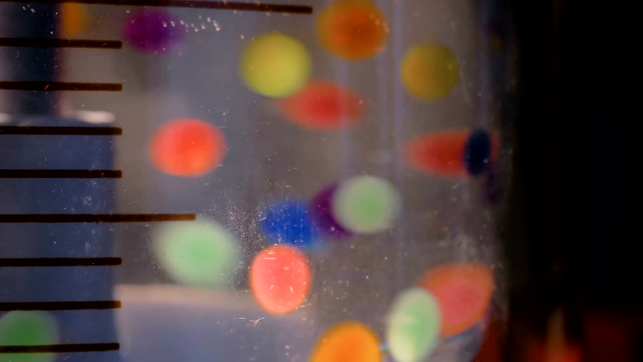 Moving colorful pills, tablets, drugs, meds in water at pharma exhibition