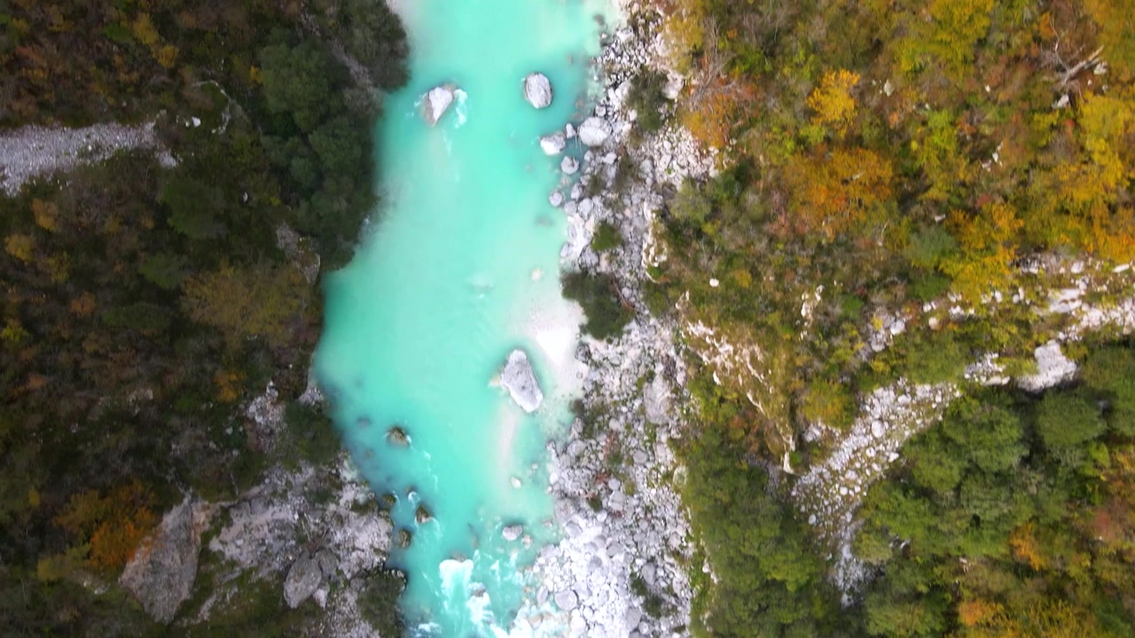 Ripresa aerea dall'alto che segue il potente fiume Isonzo (Soča) color turchese attraverso rapide impetuose, Slovenia