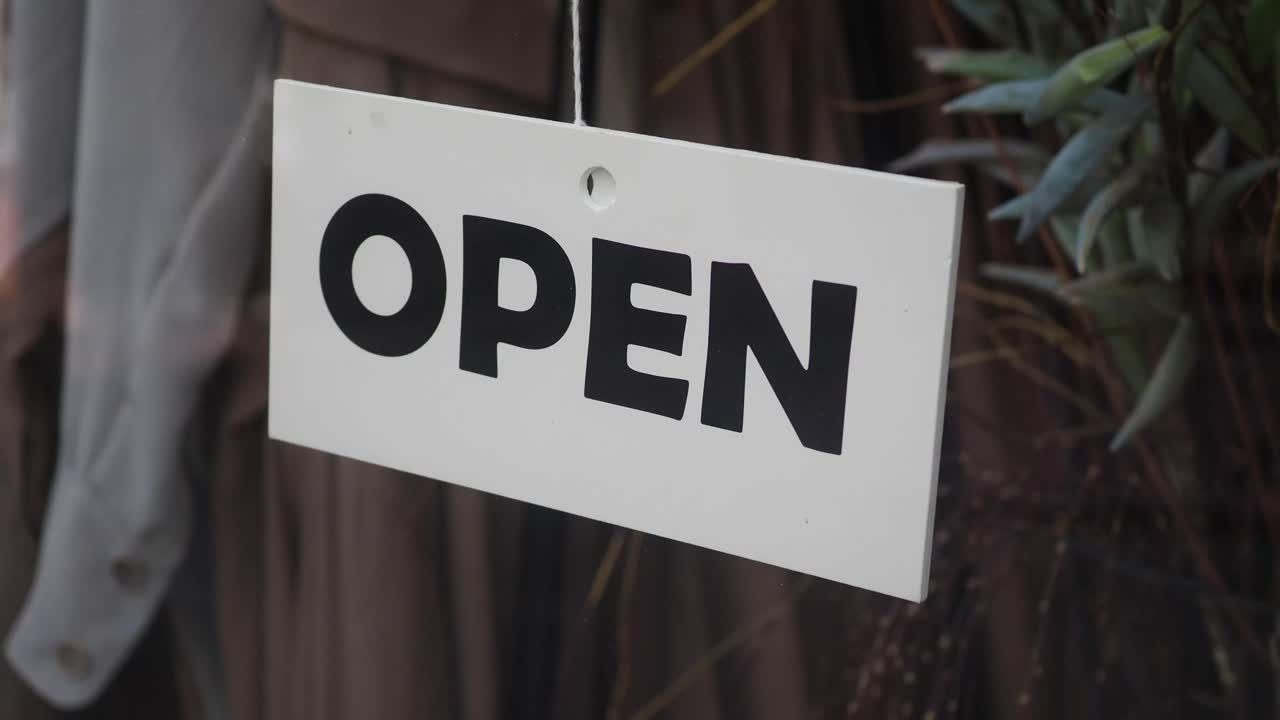 An open sign hanging in a window