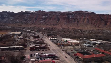 Flying-toward-the-red-rock-canyon-wall-in-Moab-Utah-during-midday,-aerial