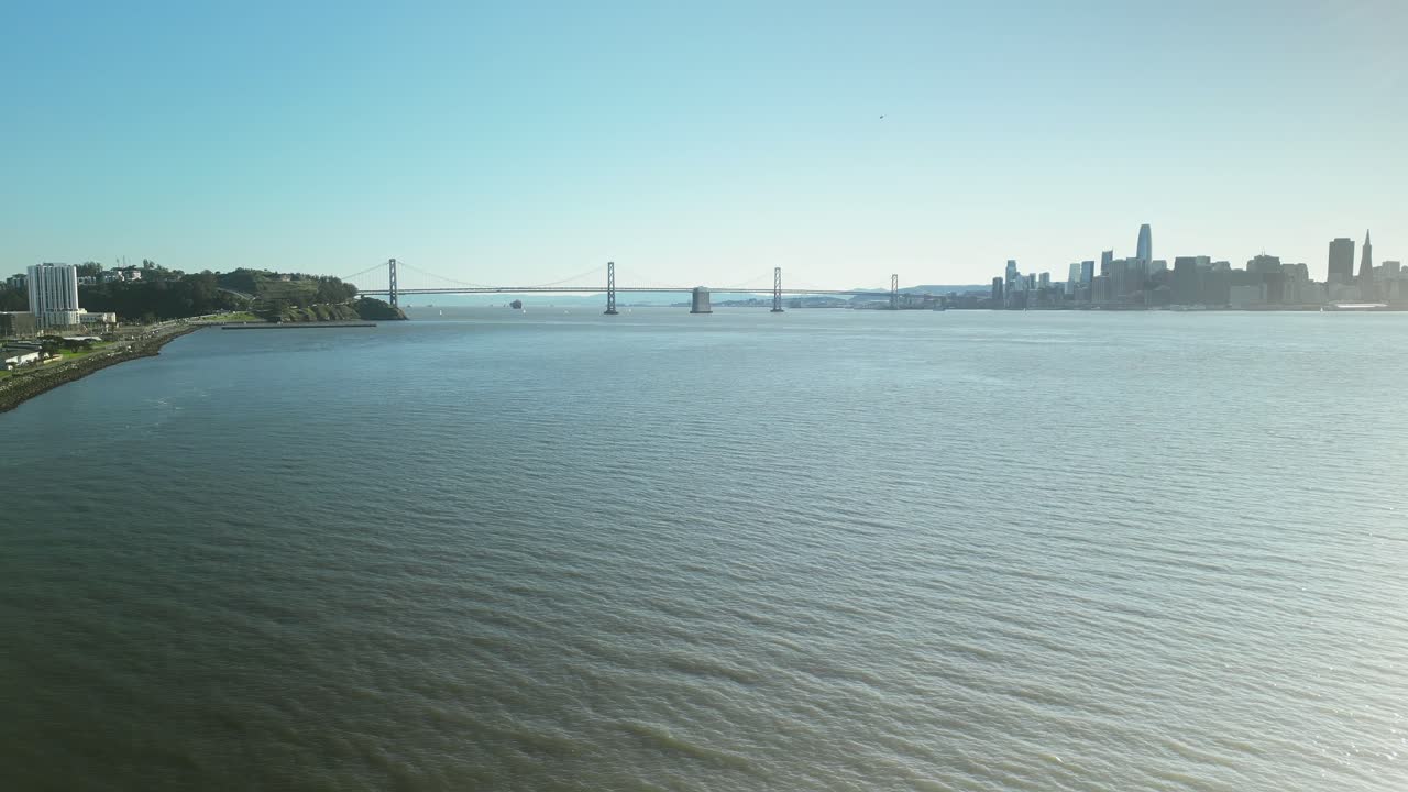 Pan drone shot of San Francisco-Oakland Bay Bridge with sunshine in California, USA