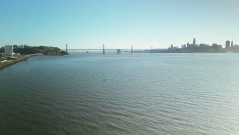 pan drone shot of san francisco-oakland bay bridge with sunshine in california, usa
