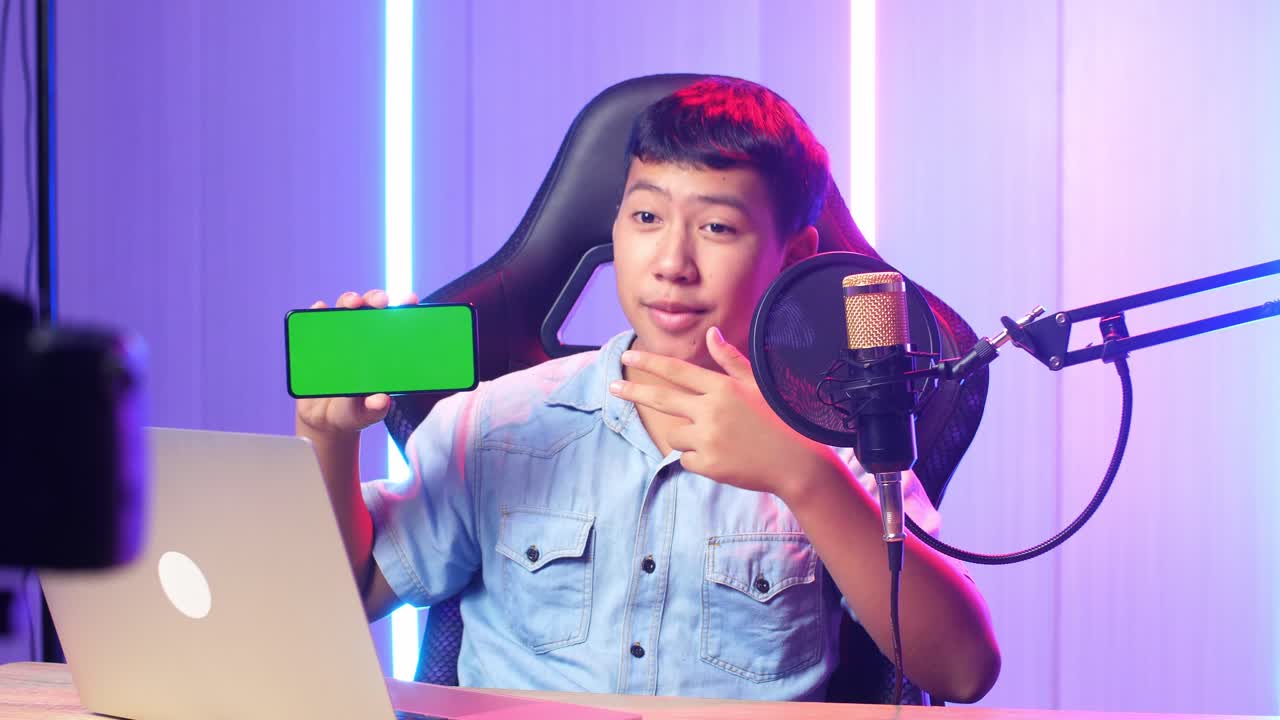 Asian Kid Boy Holding Mobile Phone With Mock Up Green Screen While Live Stream