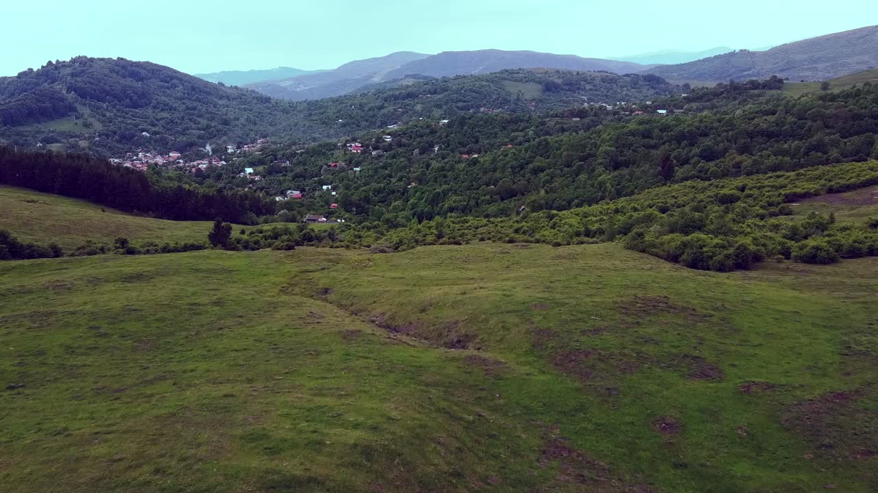 hermosa toma de drones de un valle del lado del condado, con un pueblo pintoresco en la distancia