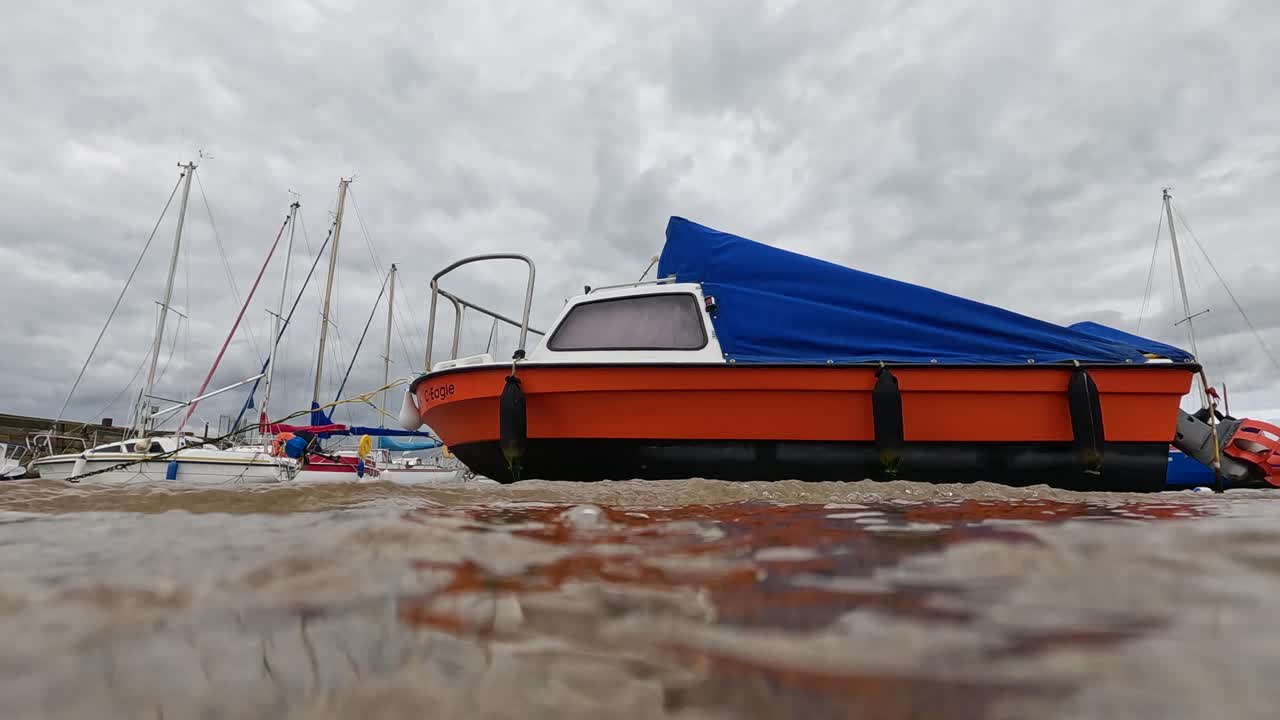 día nublado con barcos y olas suaves