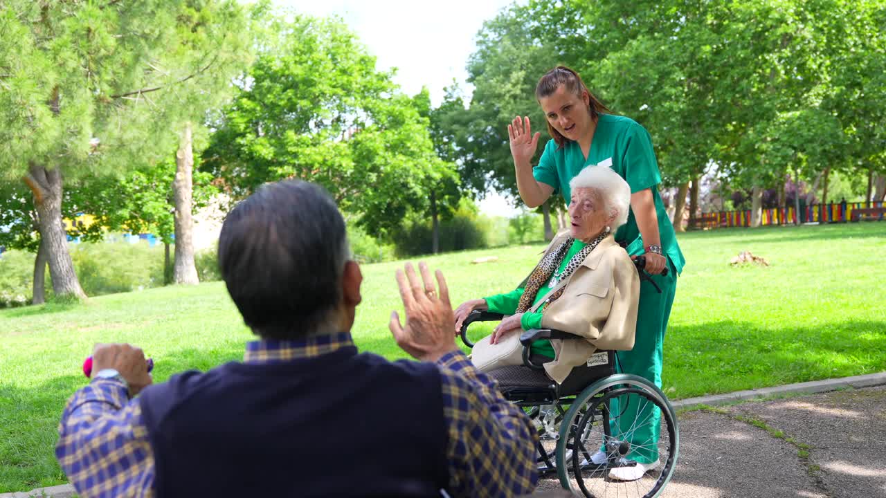 Elderly woman in wheelchair with nurse in park