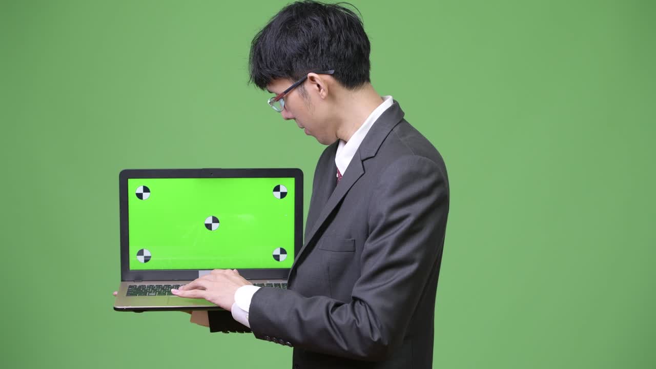 젊은 아시아 사업가 가 카메라 에 노트북 을 보여주고 있다
