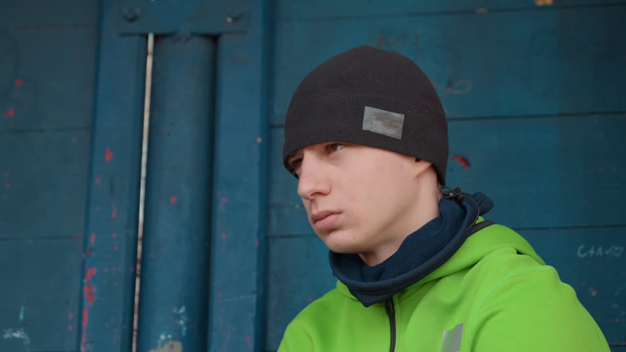 imagen tranquila y reflexiva, hombre con fondo azul, individuo sereno que reflexiona junto a una partición azul vívida, figura masculina tranquila que contempla junto a una barrera azul colorida en un entorno apacible