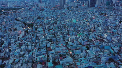 drone shot panning from left to right at twilight over densely populated and built up area of a modern asian city