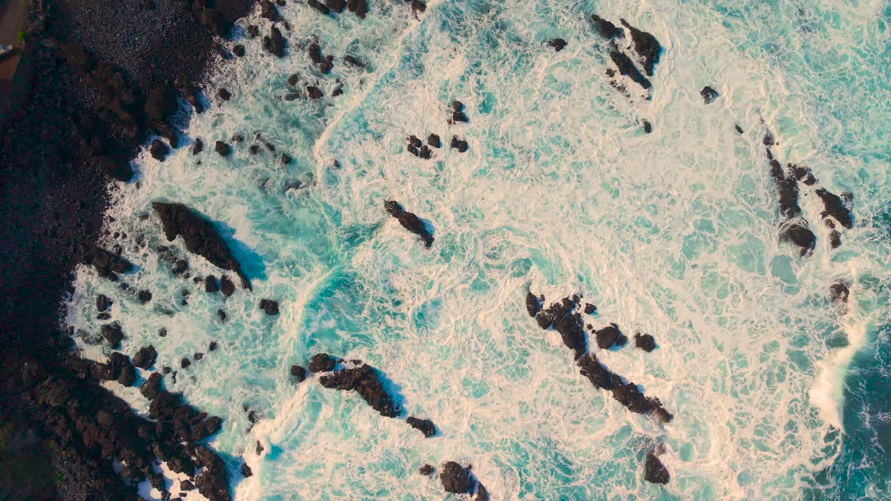 Aerial view of rough volcanic coast in Tenerife with crashing waves