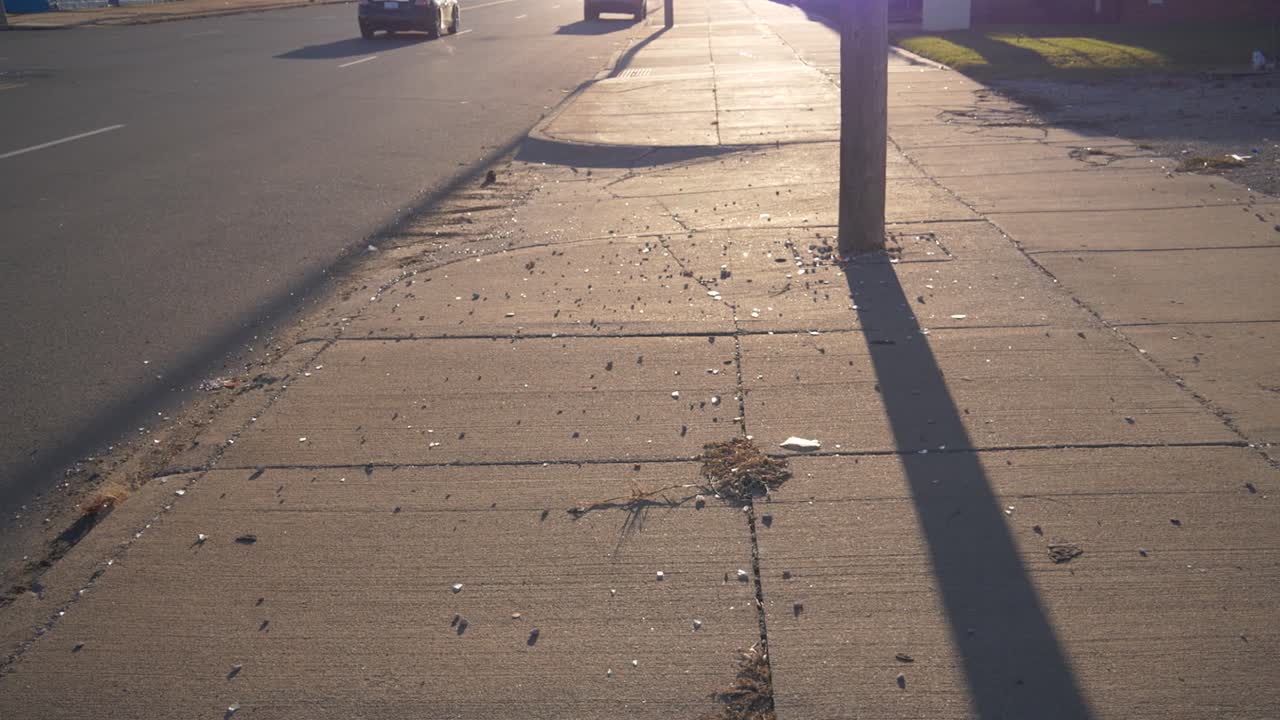 Slow motion gimbal shot of broken glass on sidewalk on the east side of Detroit