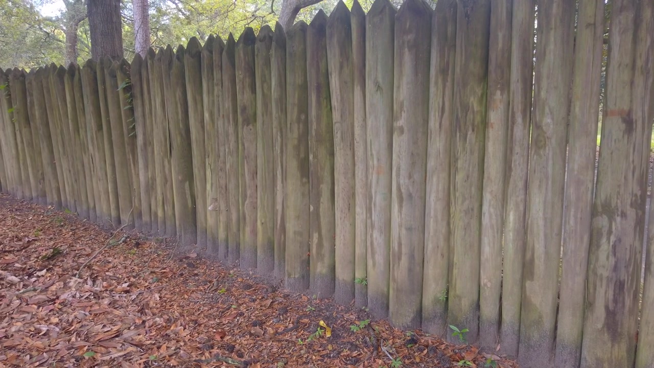 Ripresa panoramica ravvicinata con gimbal della recinzione in legno che segna il confine dello storico insediamento di Old Charles Towne a Charleston, Carolina del Sud. 4K