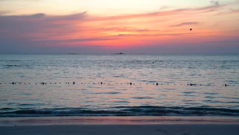 Pequeñas-Olas-En-El-Mar-De-La-Playa-Durante-La-Hermosa-Puesta-De-Sol-Roja