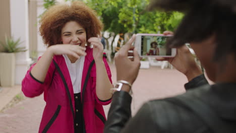 retrato de una joven y animada estudiante posando haciendo caras para su amiga tomando fotos usando un teléfono inteligente disfrutando de una diversión urbana relajada en la ciudad