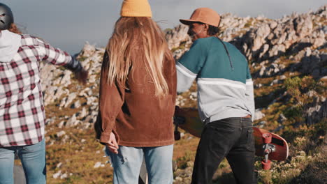 happy-multi-ethnic-skater-friends-high-five-together-enjoying-summer-vacation-longboarding-on-countryside-road-rear-view